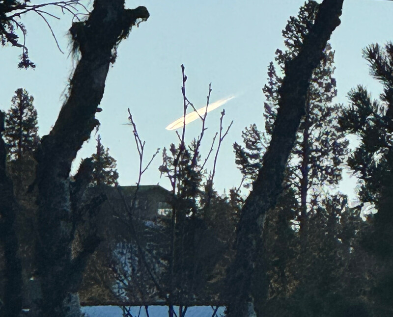 Kondensstripe fra fly i solnedgang